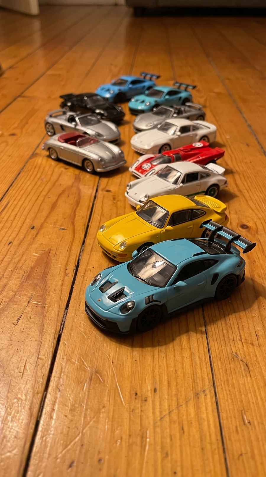 The 10 die-cast cars lined up on the floor
